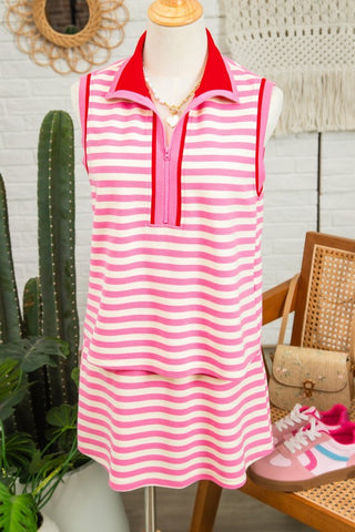 Pink and white striped dress on a mannequin with sneakers on a wooden floor.