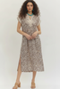A woman modeling a sleeveless midi dress with a brown and beige leopard print pattern, featuring a lace V-neckline and short lace sleeves, paired with beige heeled sandals.