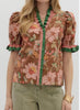 Woman wearing a floral blouse with ruffled sleeves on a white background